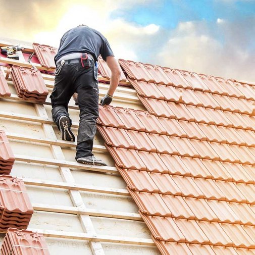 Dachdecker beim Dachdecken auf Privathaus