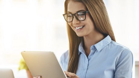 Eine Buerofrau die ein Tablet bedient